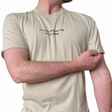 Person wearing a beige t-shirt with text on a white background