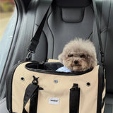 Dog in a beige pet carrier inside a car